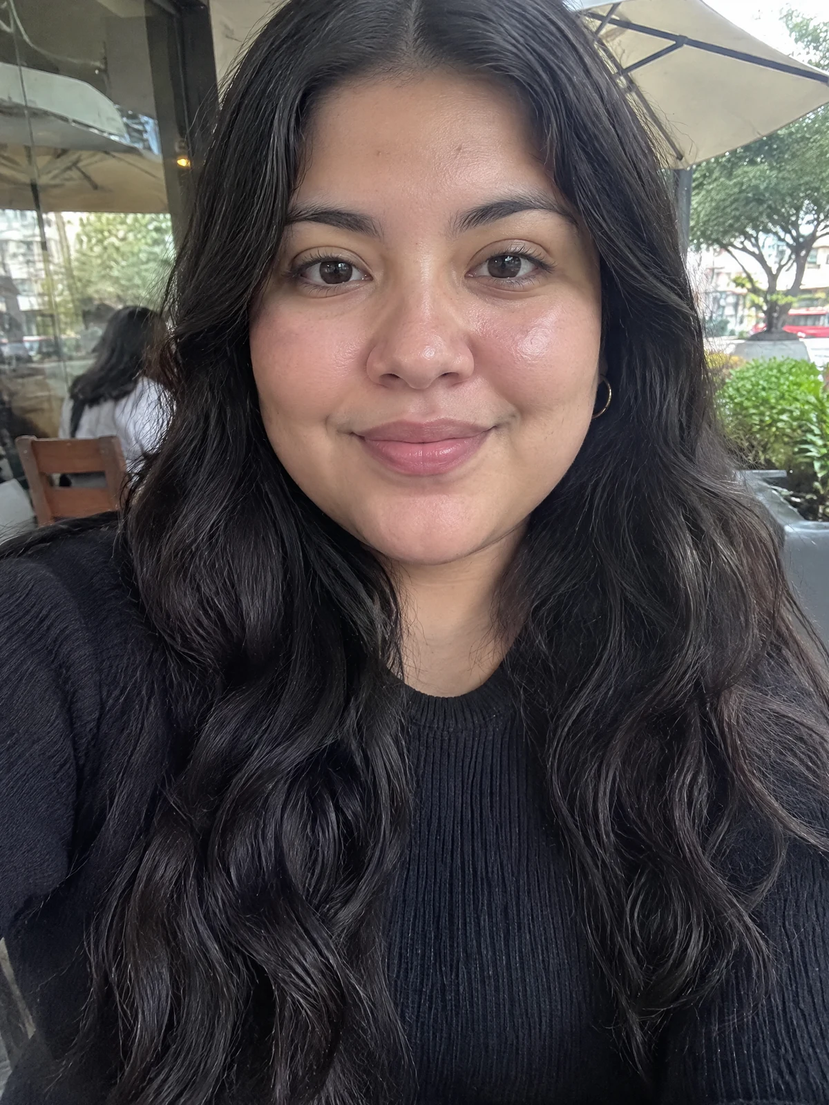 Foto de ejemplo: una mujer de frente en la terraza de un café